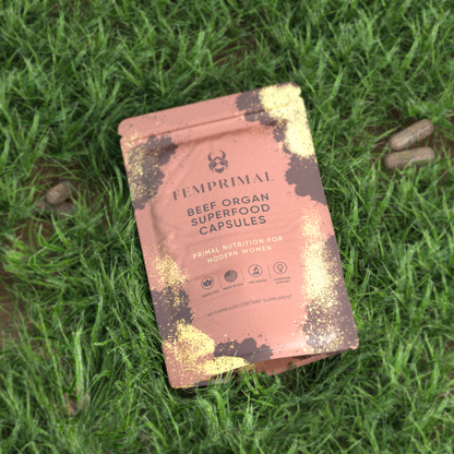 FEMPRIMAL Beef Organ Superfood Capsules pouch on natural green grass background highlighting grass-fed, hormone-free ingredients made for modern women.