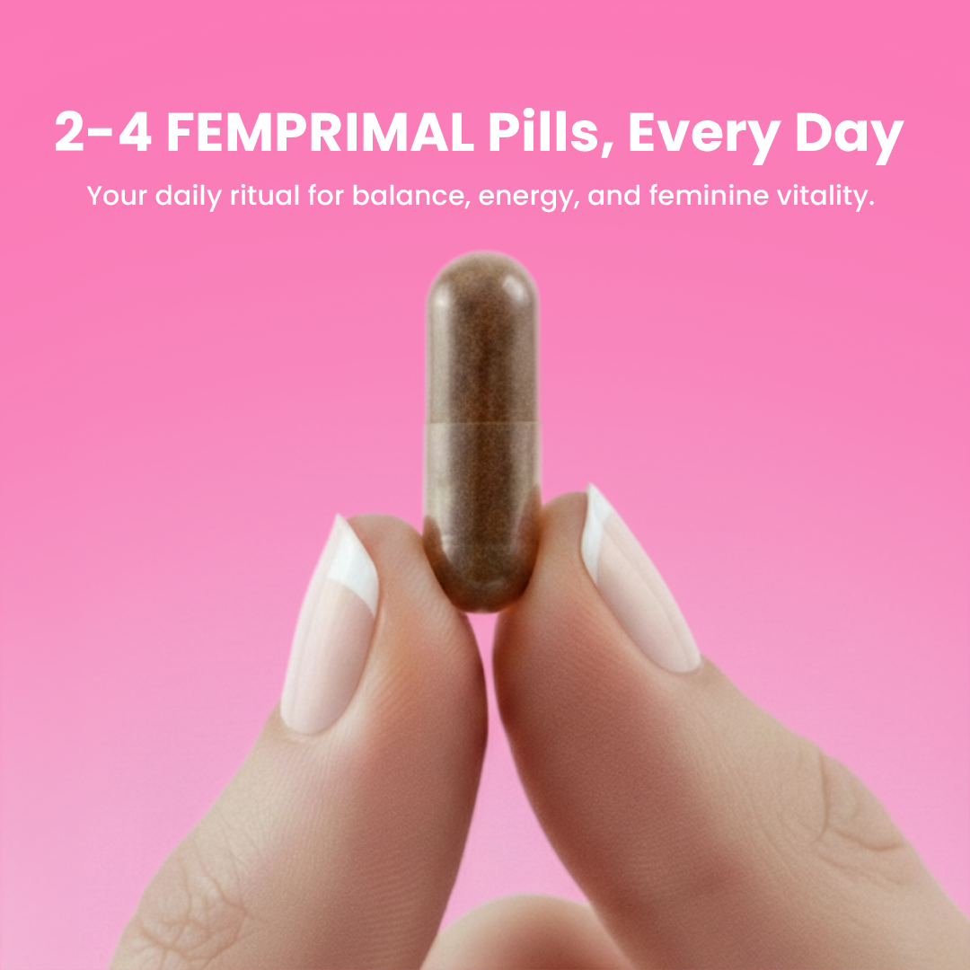 Close-up of woman holding a FEMPRIMAL capsule between fingers on a pink background, promoting daily supplement for balance, energy, and feminine vitality.