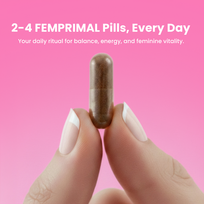 Close-up of woman holding a FEMPRIMAL capsule between fingers on a pink background, promoting daily supplement for balance, energy, and feminine vitality.